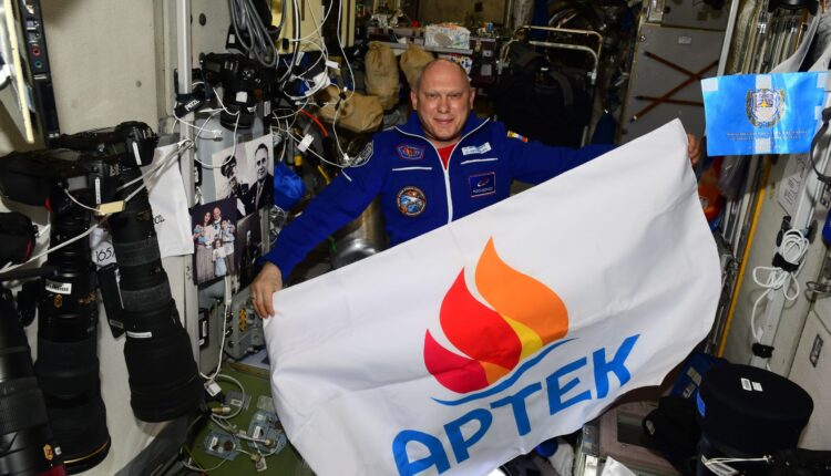 space-in-touch:-the-flag-of-the-artek-international-children's-center-and-a-picture-of-artek-residents-on-the-iss